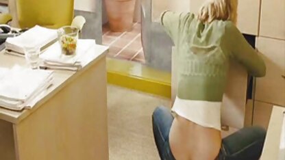 Une fille avec un film porno de lesbienne sweat-shirt et un pantalon dans le vagin se masturbe à l'aide d'une machine à sexe et d'un vibrateur